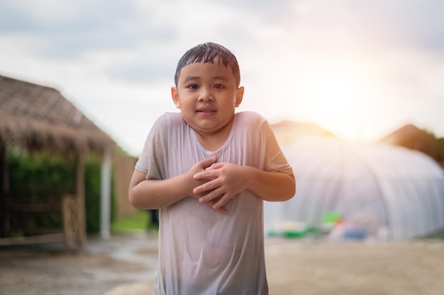 Asian kid boy wet in the rain