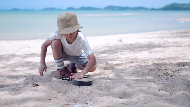 Asian kid play sand and relaxing on summer beach. Outdoor activity and lifestyle on holiday.