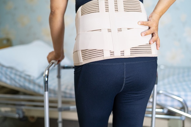 Asian lady patient wearing back pain support belt.