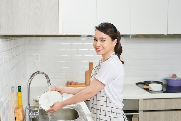 Asian lady wash a dish in kitchen room