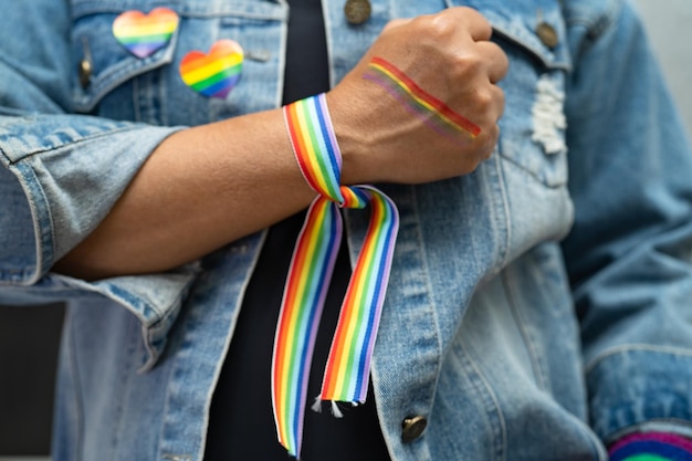 Asian lady wearing rainbow flag wristbands symbol of LGBT pride month celebrate annual in June social of gay lesbian bisexual transgender human rights