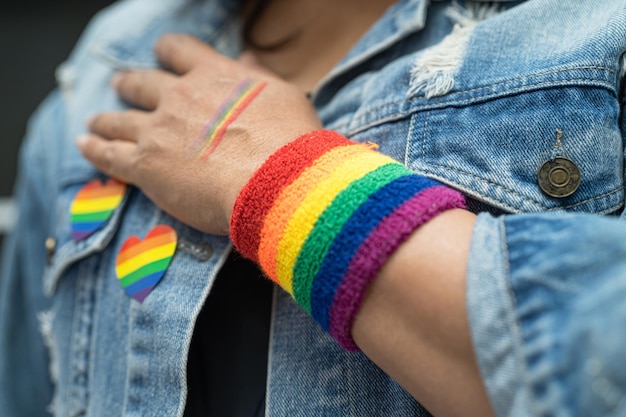 Asian lady wearing rainbow flag wristbands symbol of LGBT pride month celebrate annual in June social of gay lesbian bisexual transgender human rights