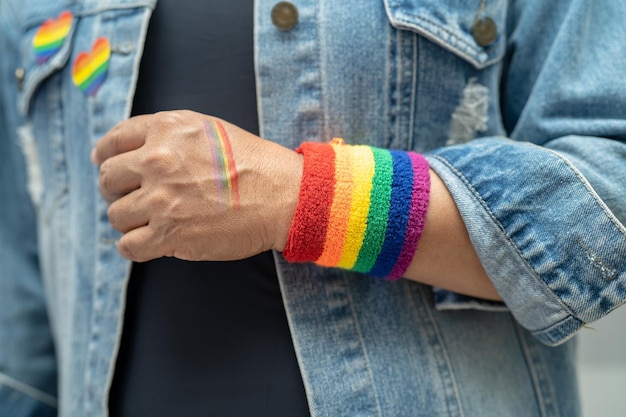 Asian lady wearing rainbow flag wristbands symbol of LGBT pride month celebrate annual in June social of gay lesbian bisexual transgender human rights