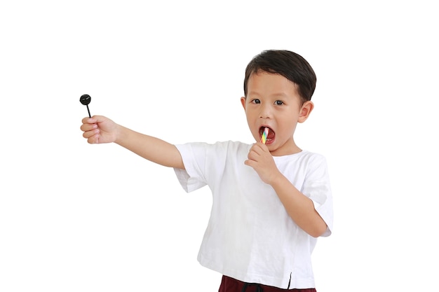 Asian little boy hold and eating lollipop candy isolated on white background. Image with clipping path