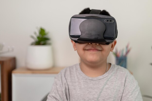 Asian Little boy with VR glasses studying sciences at homecurious student wears a virtual reality headset to study science home online study futuristic lifestyle learning