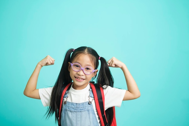 Asian little child girl raising hands up making strong gesture