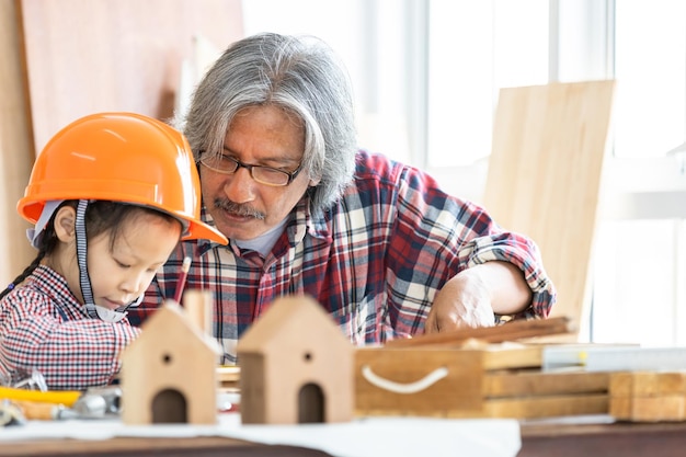 Asian little girl carpenter working on woodworking in carpentry shop Carpenter working on wood craft at workshop construction material wooden furniture Asian little girl works in a carpentry shop