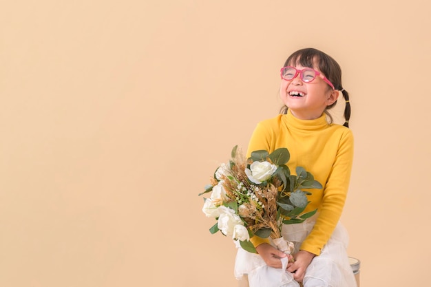 Asian little girl holding flower bouquet with cheerful and happy studio shot with copy space