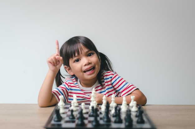 Asian little girl playing chess at homea game of chess