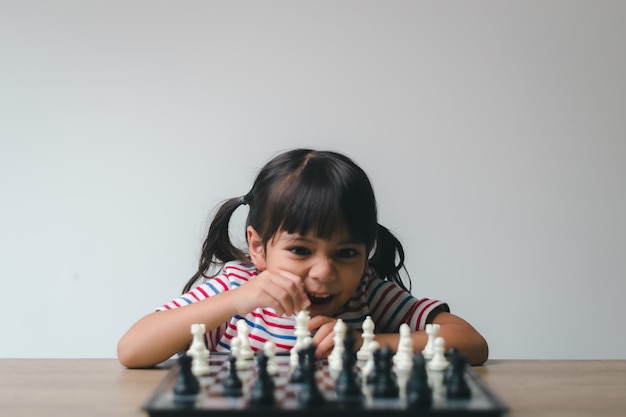 Asian little girl playing chess at homea game of chess