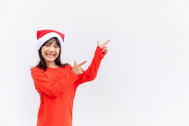 Asian little girl in red Santa hat on white background.