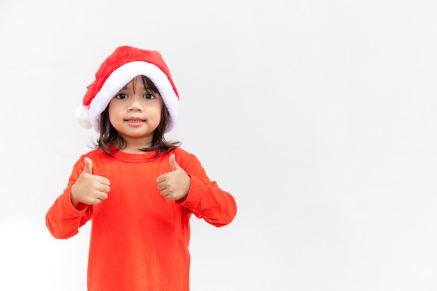 Asian little girl in red Santa hat on white background.