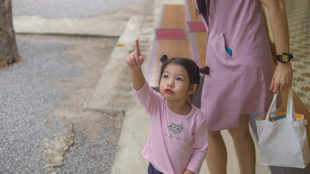 Asian little girl running and walking on grass field