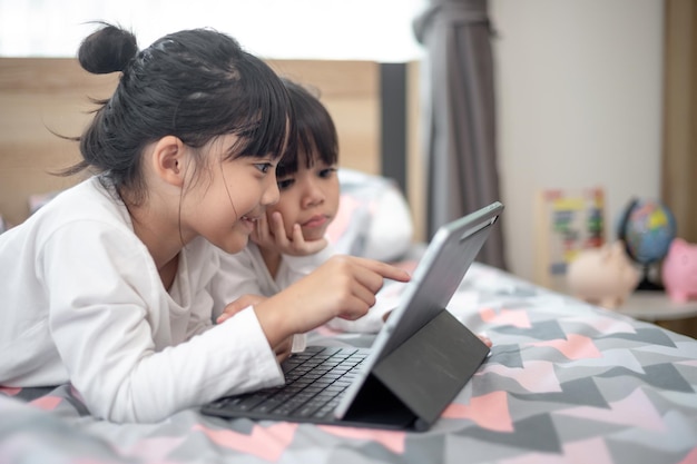 Asian little girl taking class on line and happy for Homeschool Quarantine coranavirus pandemic concept