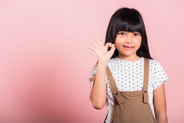 Asian little kid 10 years old showing OK gesture in sign language