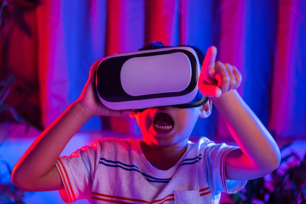 Asian little kid boy wearing virtual reality goggles experiencing reality