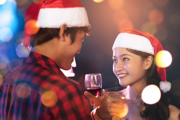 Asian lovers eye contact looking and smiling to each other in pub