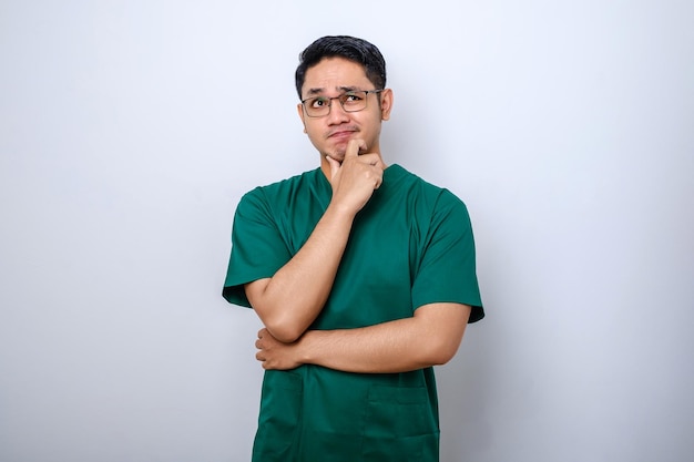 Asian male doctor in scrubs looking thinking searching for solution