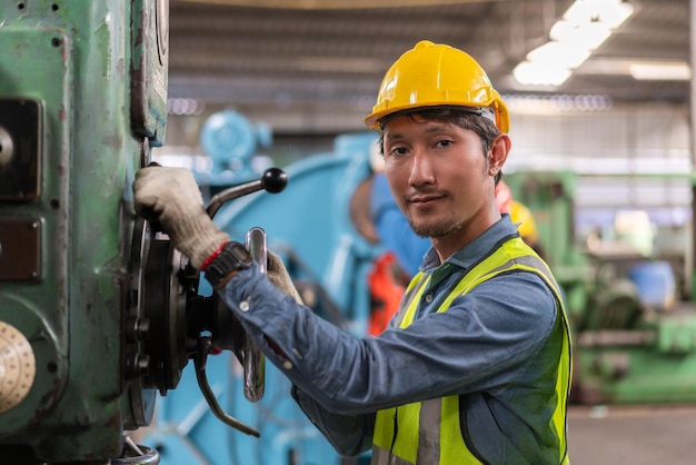 Asian male engineer checking and repairing maintenance old machine at factory Industrial