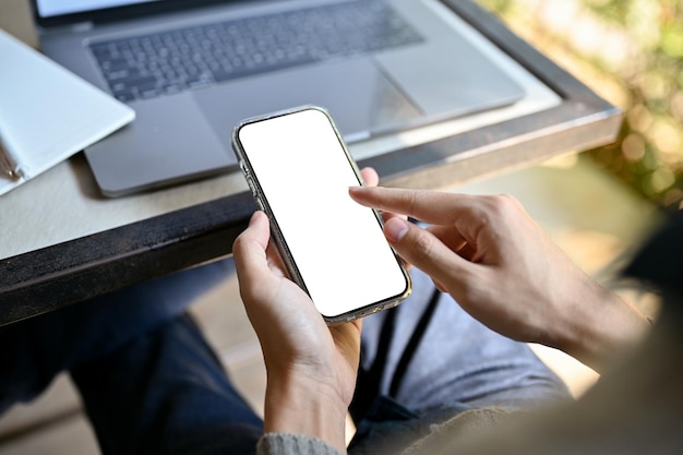 An Asian male freelancer sitting at his desk using his smartphone mobile phone mockup