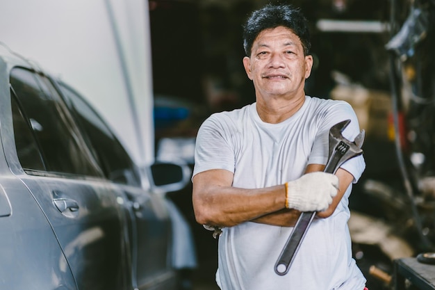 Asian male mechanic professional portrait happy smile work man in garage auto service