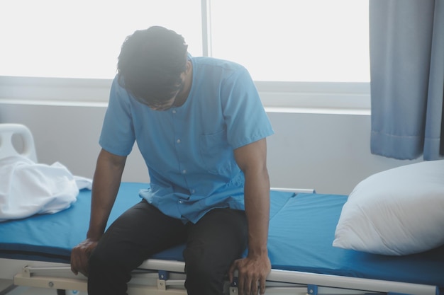 Asian male patient lying on bed with face mask in recovery room in hospital ward All people wearing mask to prevent covid19 virus infection during coronavirus pandemic The man feels lonely and bore