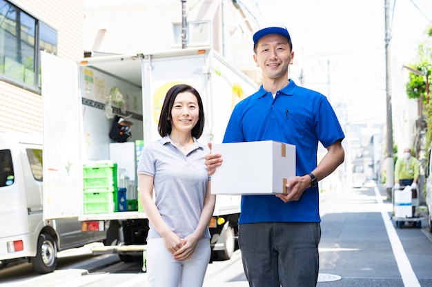 Asian male staff carrying luggage and female customers outdoors