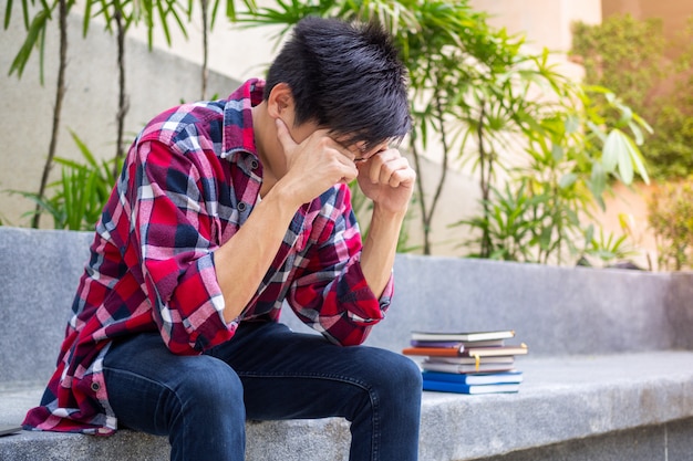 Asian male students sitting worried stressed, about the failed exam results.