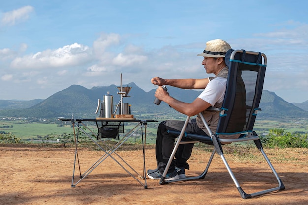 Asian male tourist grinding coffee by hand for drip coffeeto travel and drip coffee concept