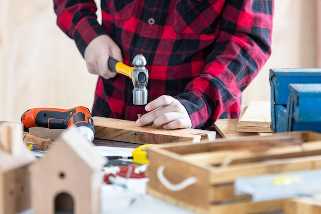 Asian man carpenter working on woodworking in carpentry shop Carpenter working on wood craft at workshop construction material wooden furniture Asian man works in a carpentry shop