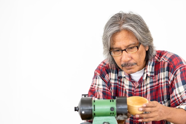 Asian man carpenter working on woodworking in carpentry shop Carpenter working on wood craft at workshop construction material wooden furniture Asian man works in a carpentry shop