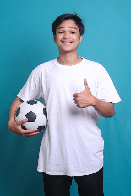 Asian man cheer up support favorite team with soccer ball showing thumb up