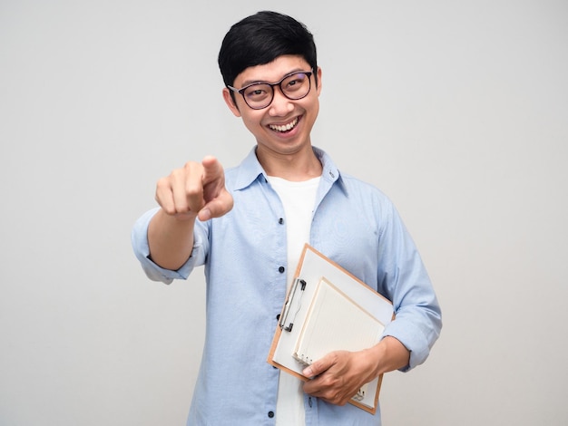 Asian man cheerful hold document and diary point finger for choose you isolated