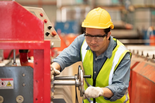 Asian man engineer working hard in factory worker employee hard hat safety control machine factory