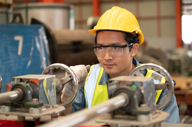 Asian man engineer working hard in factory worker employee hard hat safety control machine factory