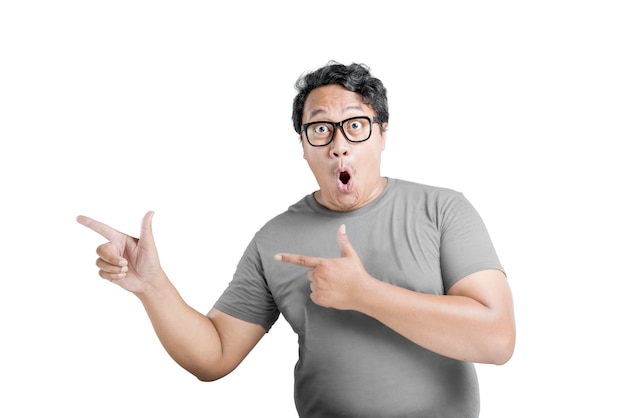 Asian man in eyeglasses pointing something with excited expression isolated over white background