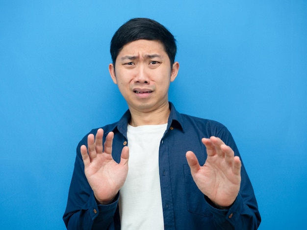 Asian man gesture scare and feeling afriad something blue background