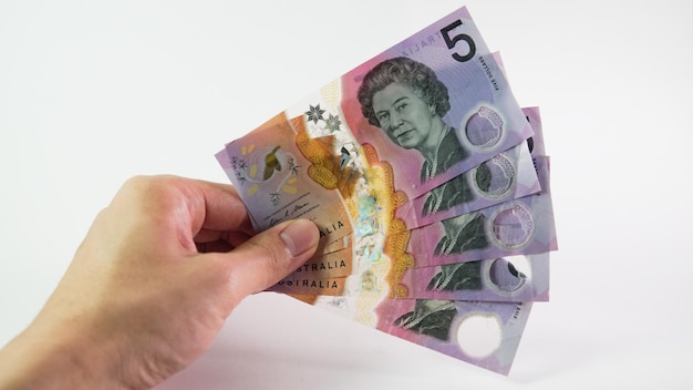 Asian man hand holding a Australian Dollar isolated on white background