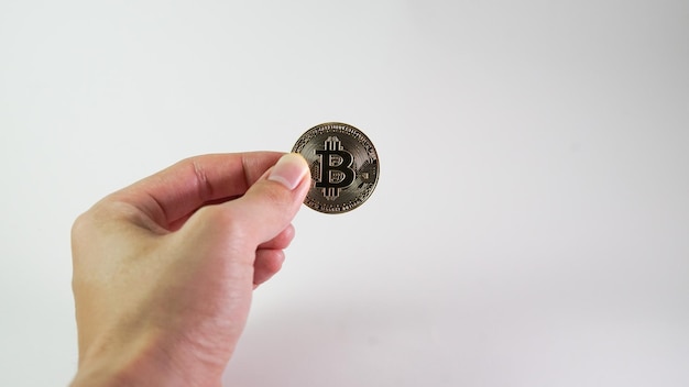 Asian man hand holding a bitcoin isolated on white background