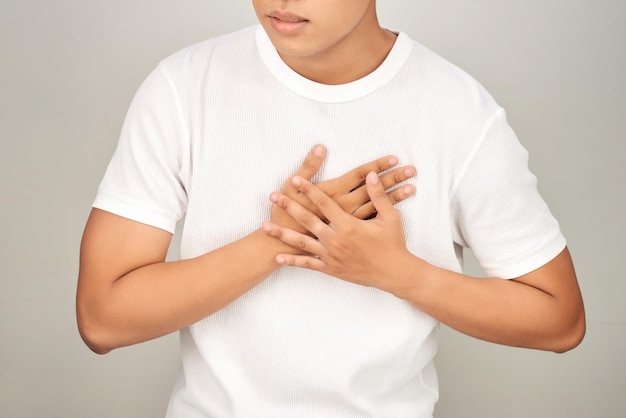 Asian man having tight chest from heart attack white background Sick person concept