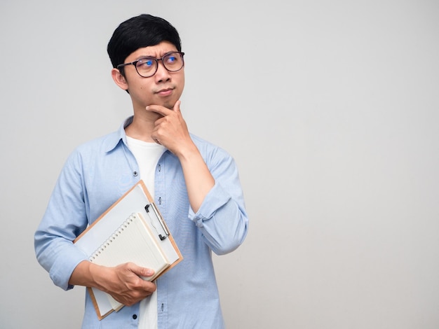 Asian man hold diary gesture thinking about learning isolated