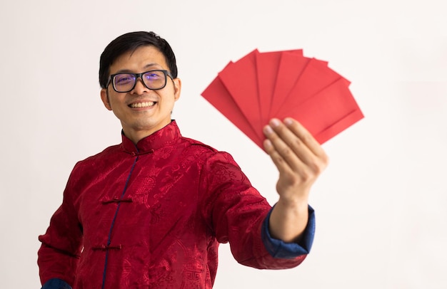 Asian man holding red envelope for give money to children in Chinese new year. Thai face smile and happy for congratulation with cheongsam dress.