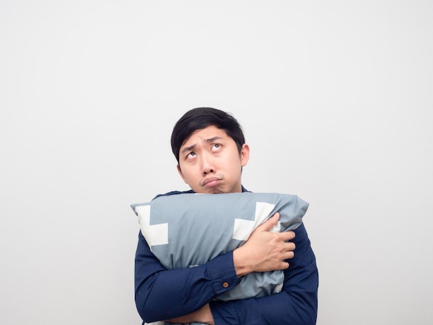 Asian man hug pillow feeling sleepy and bored looking up