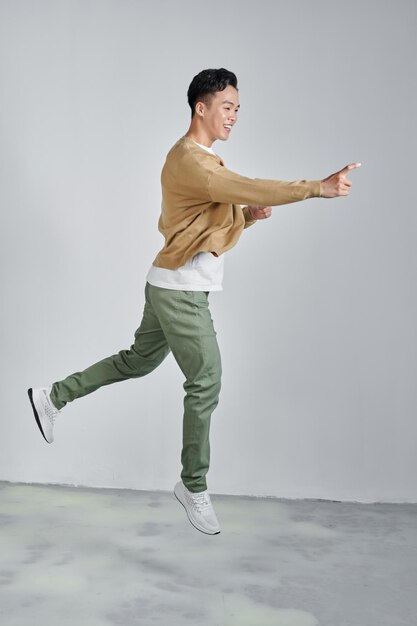 Asian man jumping and pointing