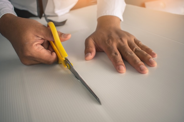 Asian man paper cutting with scissors for crafts paper 