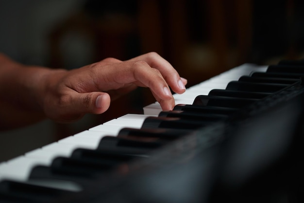 Asian man playing piano closeup on hand