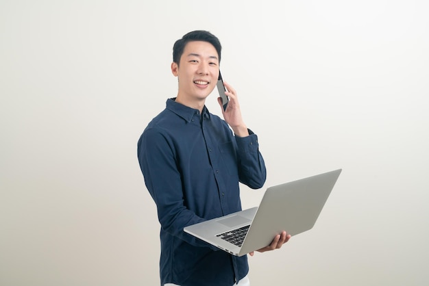 Asian man talking smartphone or mobile phone and hand holding laptop