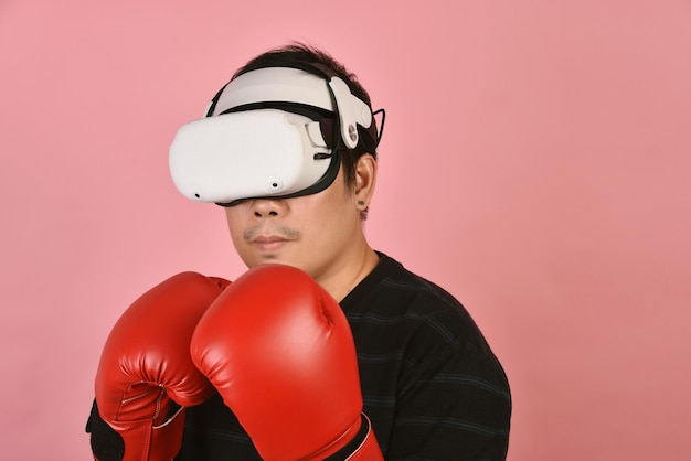 Asian man using vr glasses Working out with boxing video games application from virtual reality headset Young man enjoy new fitness experience by vr technology Studio shot