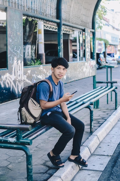 Asian man waiting at bus stop full of doodles