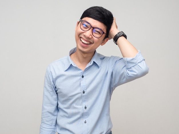 Asian man wear glasses feels shy hold his head with smile isolated